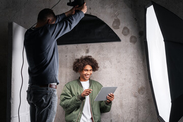 Photographer adjusting lighting during studio photo shoot