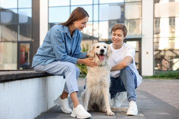 Couple with their adorable golden retriever dog in on city street