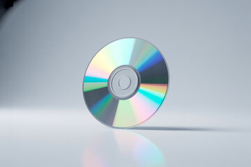 Compact disc standing on a reflective surface with a gradient background