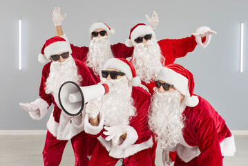 Santa group in costume uses megaphone. A dynamic team in a modern office mixes business aims with...