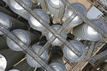 aerial view of large, stainless steel fermentation tanks at a brewery, tanks, walkways and...