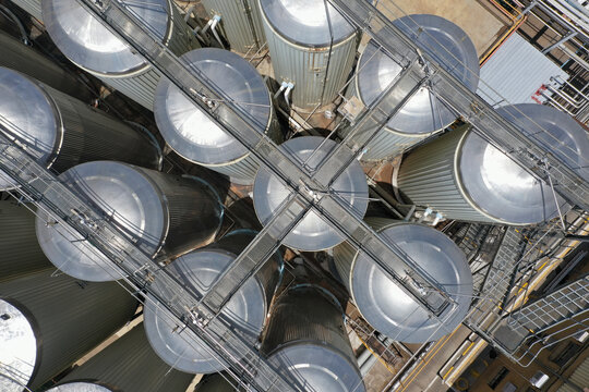 aerial view of large, stainless steel fermentation tanks at a brewery, tanks, walkways and platforms, for maintenance and operational access