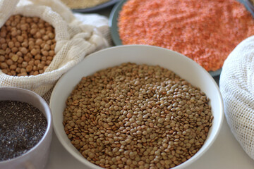 Bowls and bags full of various healthy grains and legumes. Selective focus.