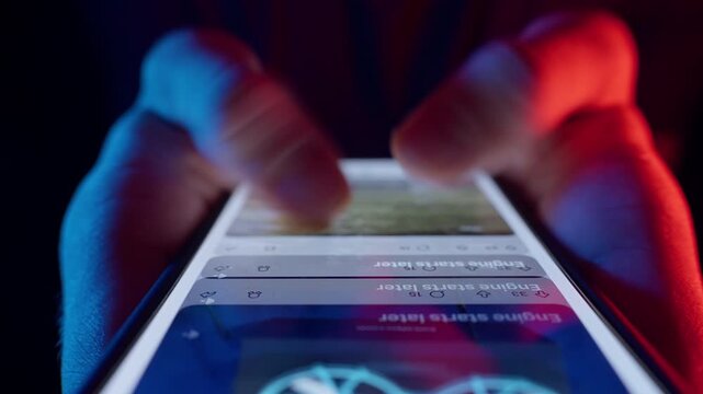 Man Rapidly Scrolls Social Media Feed with Two Fingers on Smartphone Screen Using Fast Dolly Slider Motion and Neon Light Showing the Whole Life is in the Smartphone