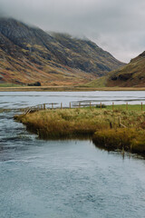 Loch Achtriochtan is a small lake in Glencoe, Scotland, famous for the iconic River Coe and the white Achnambeithach Cottage, which sits at its south end in the Scottish Highlands next to a waterfall