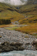 Loch Achtriochtan is a small lake in Glencoe, Scotland, famous for the iconic River Coe and the white Achnambeithach Cottage, which sits at its south end in the Scottish Highlands next to a waterfall