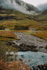 Loch Achtriochtan is a small lake in Glencoe, Scotland, famous for the iconic River Coe and the white Achnambeithach Cottage, which sits at its south end in the Scottish Highlands next to a waterfall