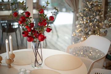 Plants in a transparent vase. Interior in light colors. A plant stands on a table.