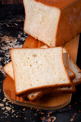 Wheat toast bread sliced on wooden cutting board. Fresh baked loaf