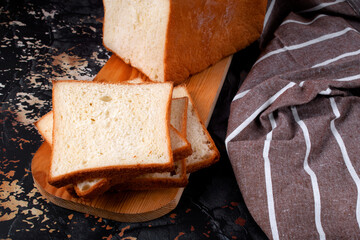 Wheat toast bread sliced on wooden cutting board. Fresh baked loaf