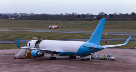 Cargo plane in the process of unloading pallets with imported products