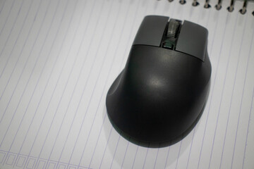 Ergonomic Wireless Computer Mouse on Lined Notepad