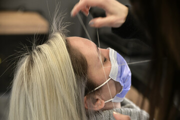 Beautician Shaping Eyebrows with Thread in Beauty Salon