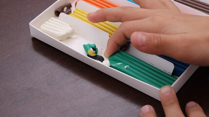 hand holding yellow plasticine, top view