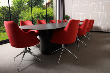 Table and chairs near large window in conference room. Interior design