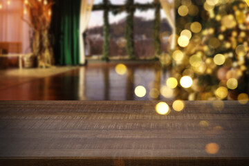 Empty wooden table in room with Christmas tree, bokeh lights. Space for design