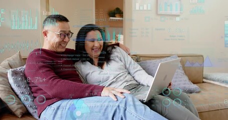 Senior man opening laptop and activating animated business charts as couple analyzing data intently - Powered by Adobe