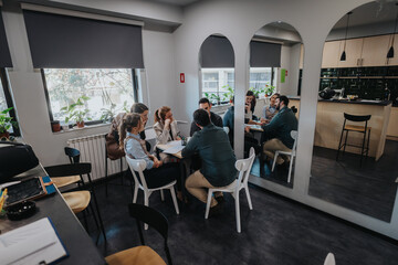 People engaged in a business meeting in a contemporary office space with natural light.