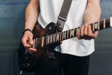 Concert view of an electric guitar player with vocalist and rock band performing in a club, male...