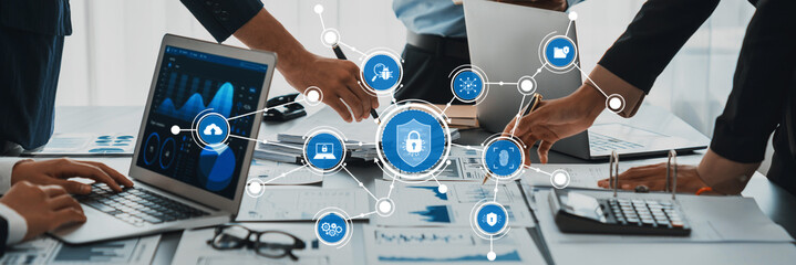 A dynamic office scene showcasing a team collaborating on cybersecurity strategy, leveraging data insights and technology tools for effective decision-making and growth. Amity