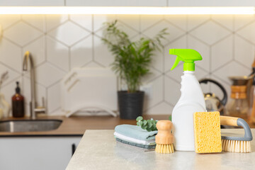 Eco cleaning products against the background of the kitchen. Eco-friendly home cleaning. A bottle of natural detergent surfaces, eco brushes, sponges, and rags. Cleaner concept.Cleaning supplies.