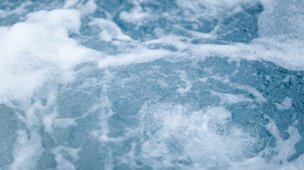 Close-up of foamy water with bubbles and texture in shades of blue and white