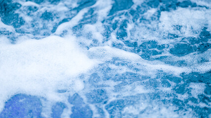Close-up of foamy water with bubbles and a blue hue, creating a refreshing scene