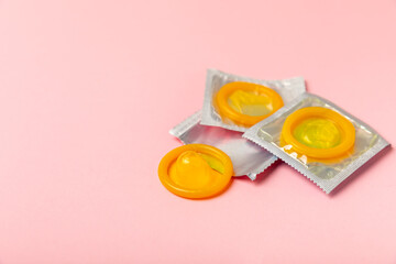 Condoms on a colored background. Colorful fruit-themed condoms in packaging. Safe sex concept. Contraceptive. Different birth control methods. Aids prevention. World AIDS Day. Sexual health.