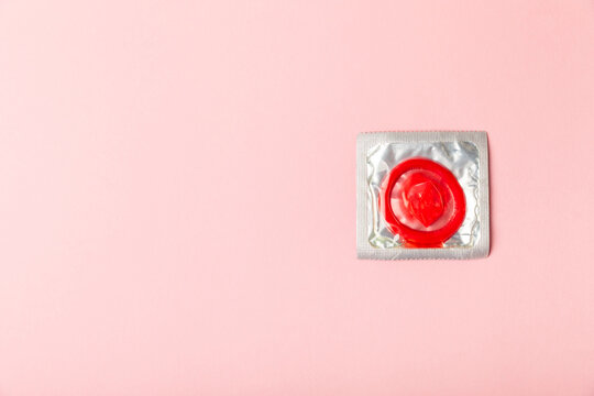 Condoms on a colored background. Colorful fruit-themed condoms in packaging. Safe sex concept. Contraceptive. Different birth control methods. Aids prevention. World AIDS Day. Sexual health.