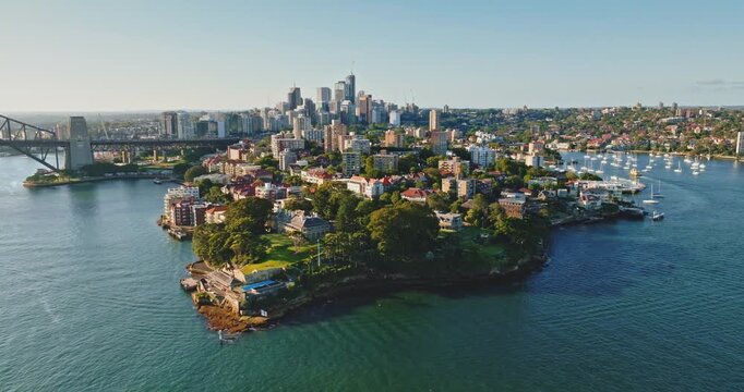 Sydney iconic cityscape and Sydney Harbor Bridge span across horizon. Modern city buildings and beautiful nature showcasing Australia dynamic urban landscape and natural beauty. Aerial drone footage