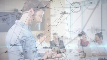 Bearded man tapping tablet visualizing network data overlay around colleagues at business meeting - Powered by Adobe