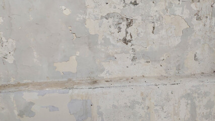 Damp stains and cracked paint on white wall from moisture leakage