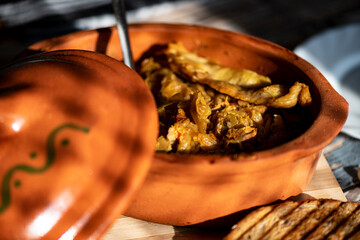 A bowl of cooked cabbage served in a rustic brown dish, showcasing its soft texture and warm, comforting appearance. The natural colors and simple presentation make this image suitable for traditional
