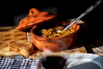 A bowl of cooked cabbage served in a rustic brown dish, showcasing its soft texture and warm, comforting appearance. The natural colors and simple presentation make this image suitable for traditional