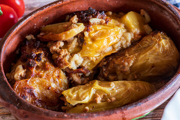 Traditional cabbage rolls (sarma) served in a rustic brown bowl, showcasing tender leaves stuffed with a savory meat and rice filling. The warm, hearty dish is highlighted by natural lighting, emphasi