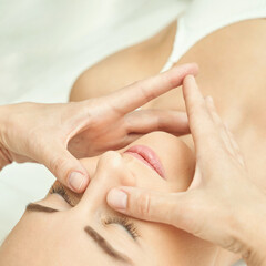 Caucasian female receiving facial massage relaxation spa treatment close-up.