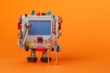 A toy mechanical robot holds repair tools. A robot mechanic handyman repairman character with a...