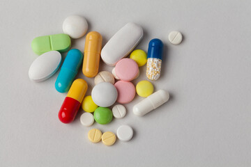 Macro view tablets pills capsules of different shapes, sizes and colors. macro view. gray paper background