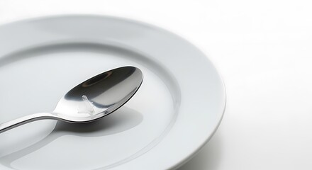 Stainless Steel Spoon on White Plate in Minimalist Kitchen Setting