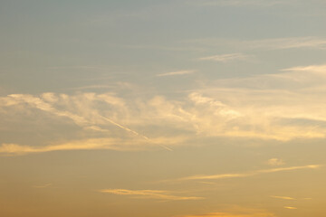 Golden sunset sky with soft clouds in tranquil evening light