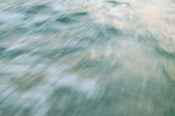 Abstract motion blur of water waves in soft pastel hues