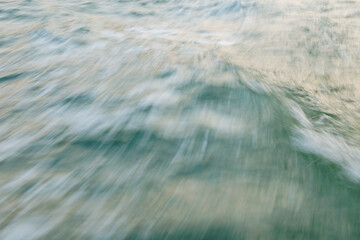 Abstract motion blur of ocean waves with blue and green hues