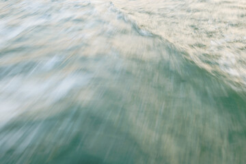 Abstract motion blur of ocean waves in soft pastel hues