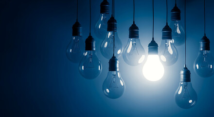 Many light bulbs are hanging from the ceiling, one is glowing brightly