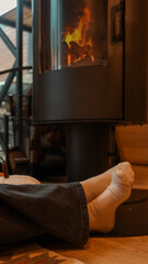 Relaxing by the Fireplace: Cozy Feet and Warm Flames in a Modern Home