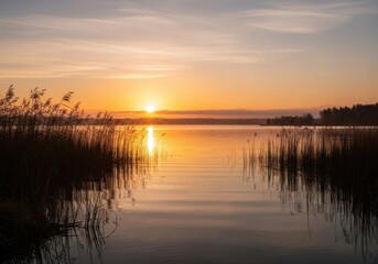 Obraz premium Serene sunset over calm water reflecting golden hues amidst natural scenery