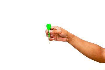 Hand holding a green dart ready to throw on a white background in a studio shot
