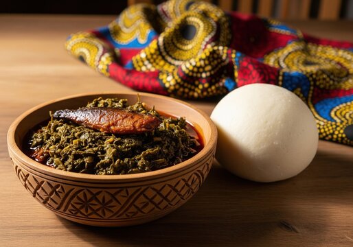 Traditional african saka-saka cassava leaf stew with fish served with a ball of fufu
