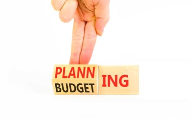 Budgeting and planning symbol. Concept words Planning to Budgeting on beautiful wooden cubes. Beautiful white background. Businessman's hand. Business, budgeting and planning concept. Copy space.