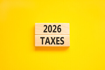2026 taxes new year symbol. Concept words 2026 taxes on beautiful wooden blocks. Beautiful yellow paper background. Business and 2026 taxes new year concept. Copy space.